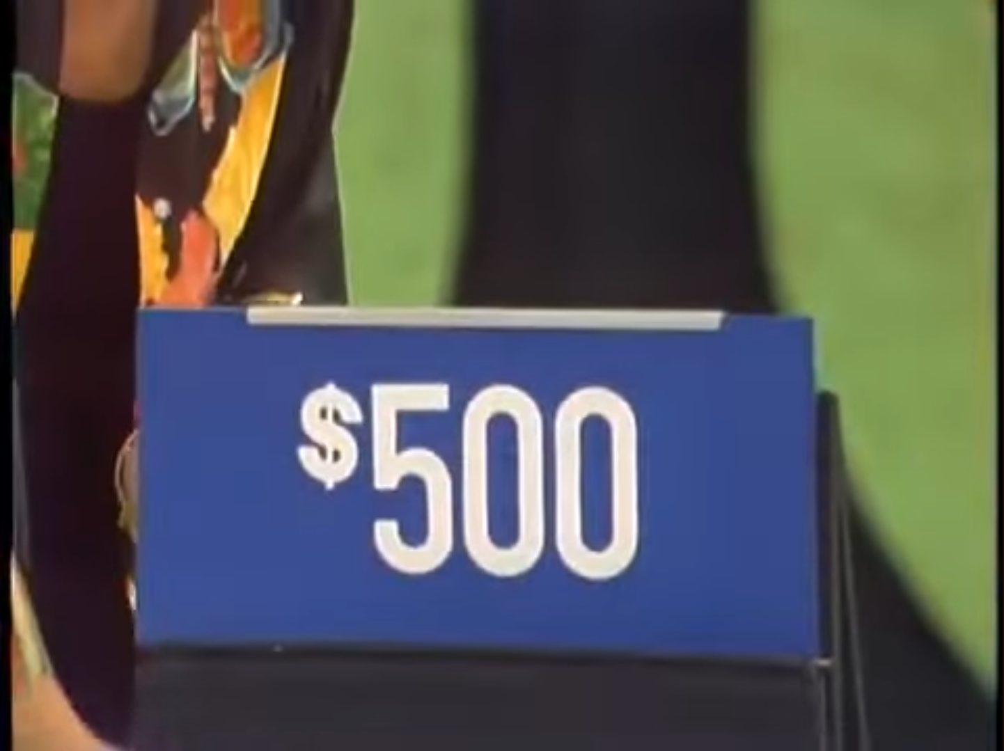 0 prize displayed on a blue sign in a game show setting.
