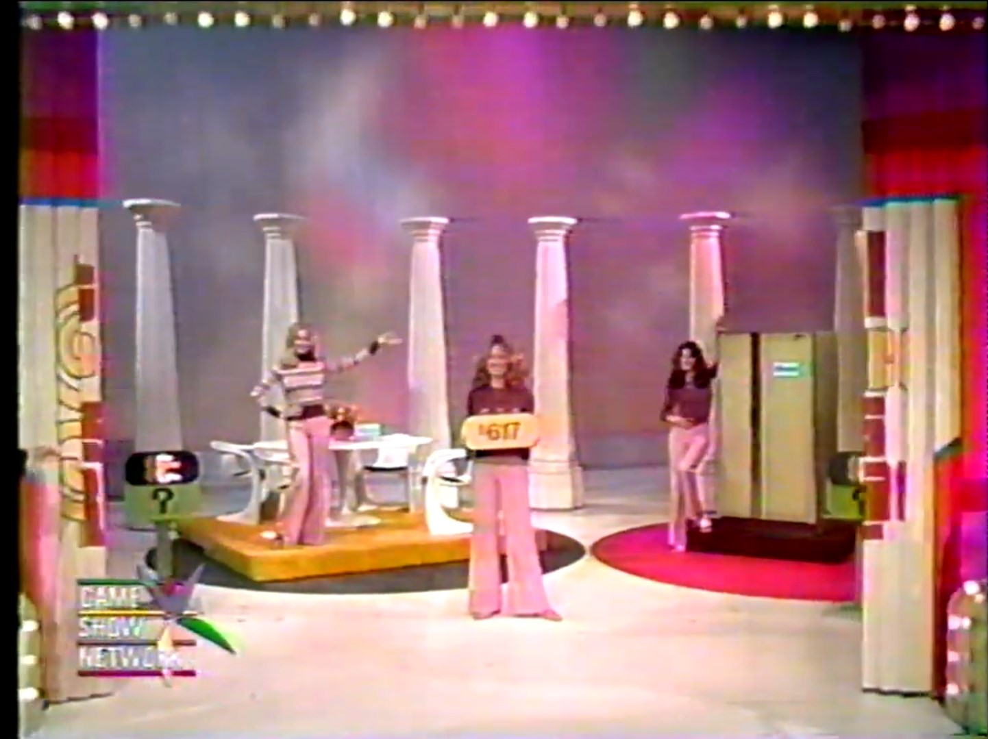 Contestants on stage during the One Right Price game, featuring a price tag of 7 and two prizes: a dinette set and a refrigerator.