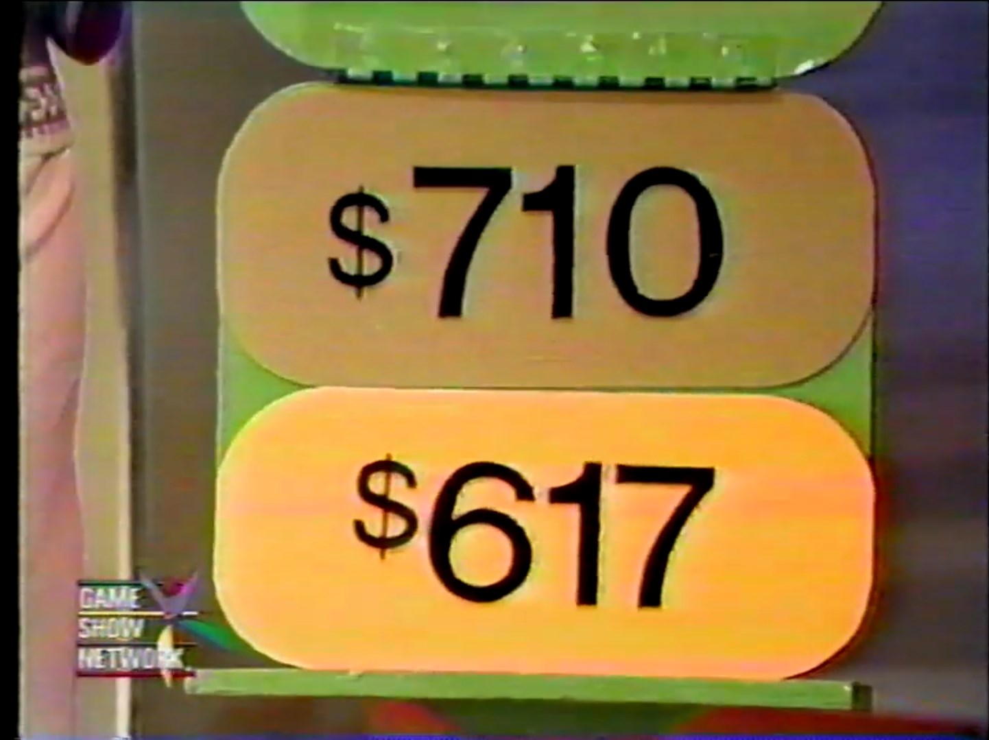 A display showing two price tags: one reads 0 and the other 7, representing prices in a game show context.