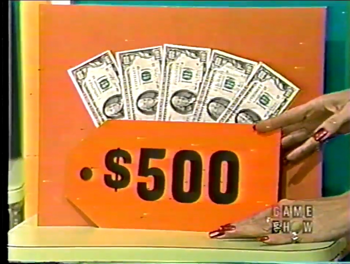 0 cash displayed on a game show stage with bills in the background.