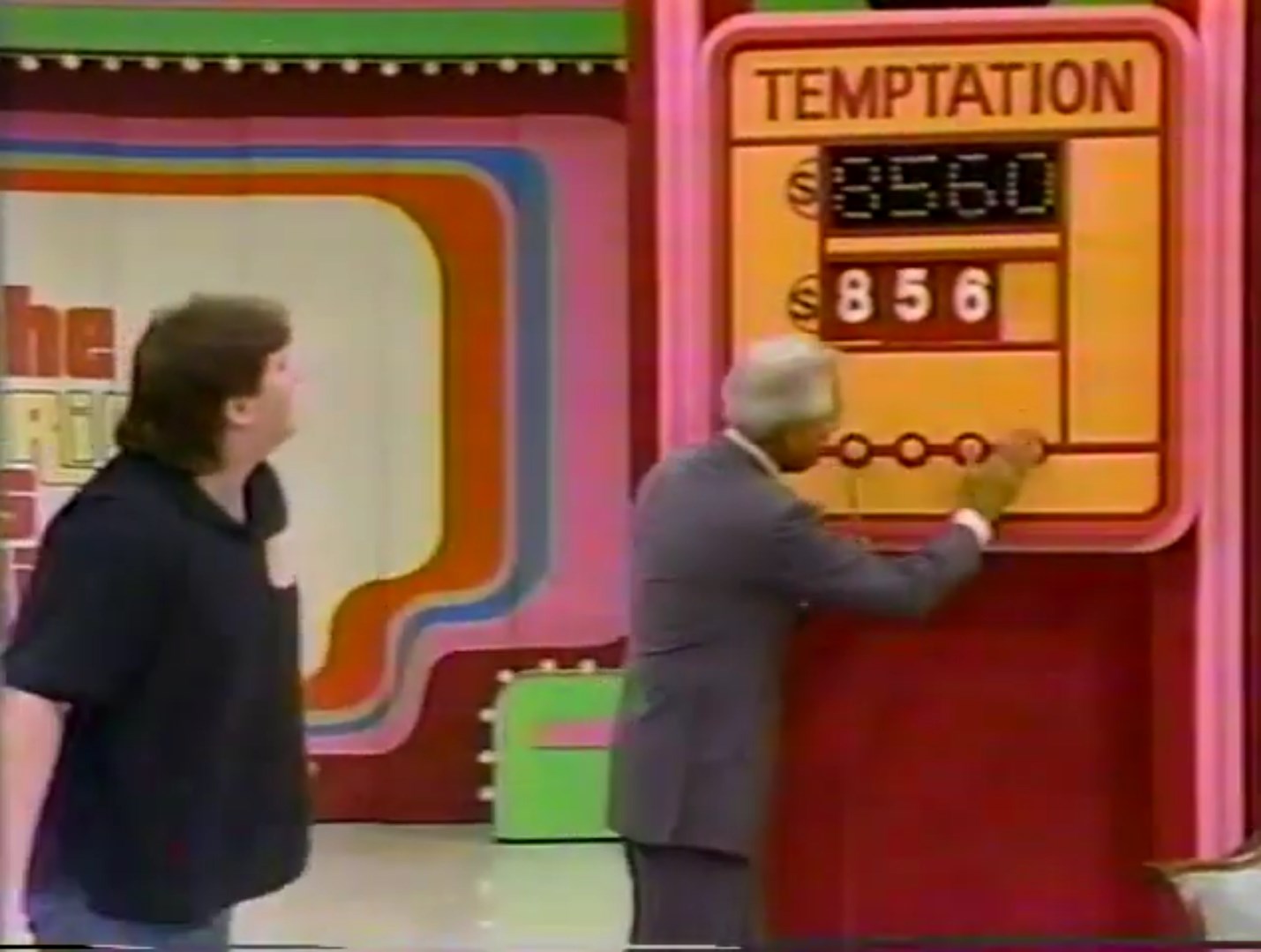 A game show host points to a pricing board labeled 'TEMPTATION' while a contestant looks on, with the displayed guess price 60 and the reveal reading 6.