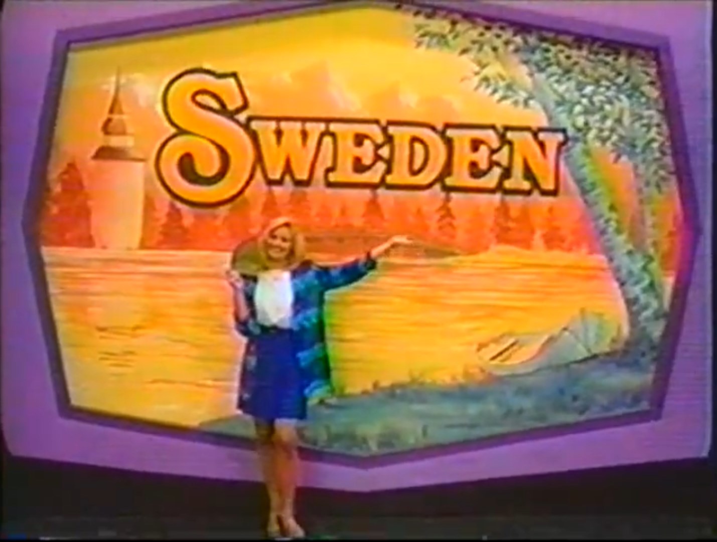 A woman in a blue outfit stands next to a colorful backdrop displaying the word 'SWEDEN' with forest and water imagery.