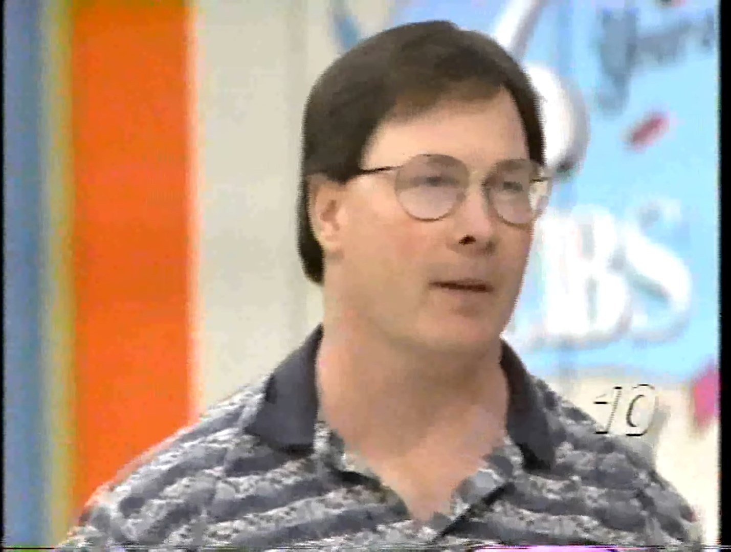 A contestant from The Price is Right, wearing glasses and a patterned shirt, appears focused while participating in a game show.