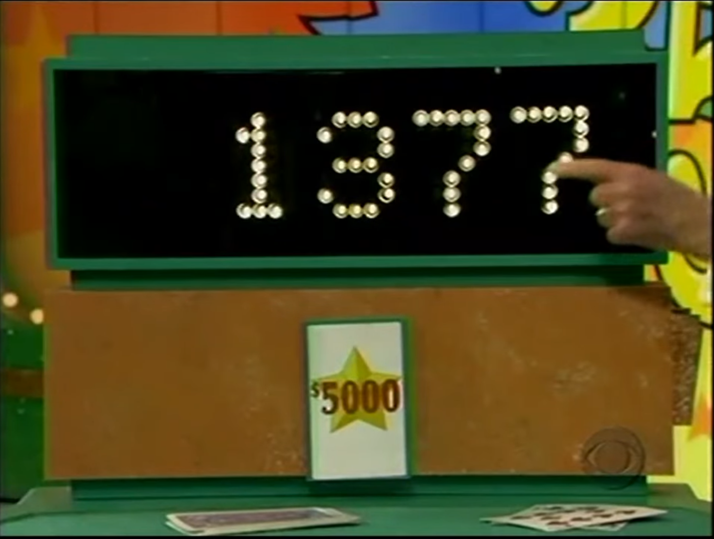 A game display board showing the number 1377 illuminated with light bulbs, indicating a contestant's bidding amount in a card game.