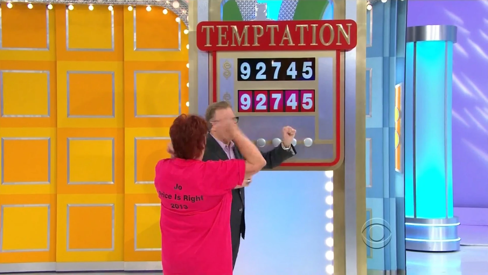 Contestant celebrating in front of the Temptation game board displaying the number 92745.