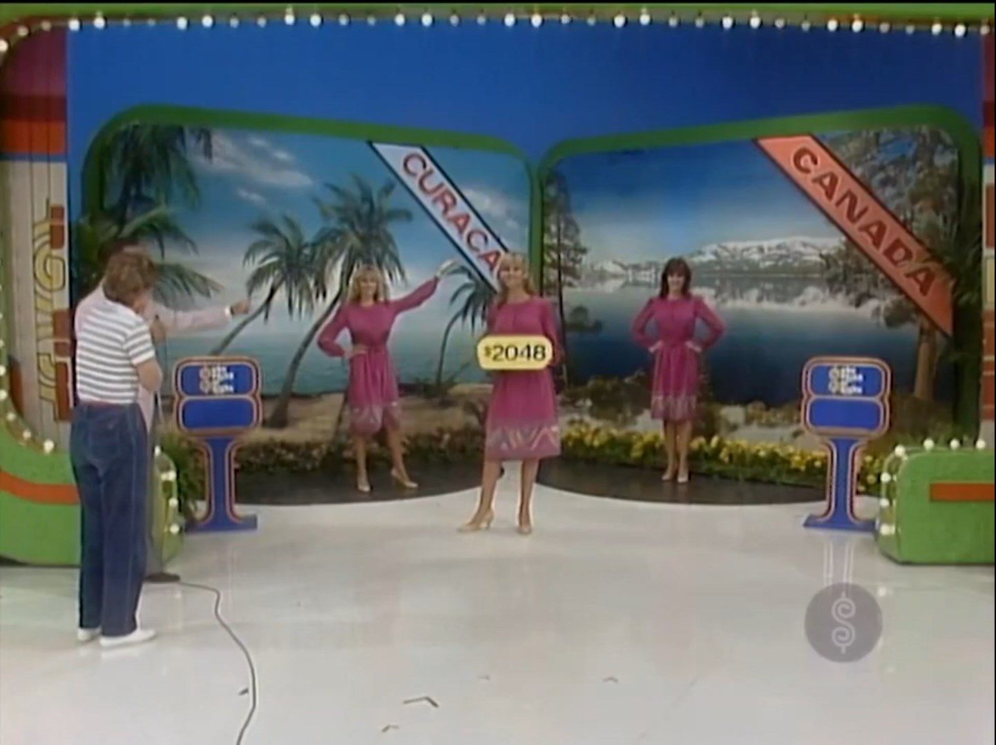 Contestants on The Price is Right game show with a price tag of 48, featuring two models in pink dresses and banners for 'CURACAO' and 'CANADA' in the background.