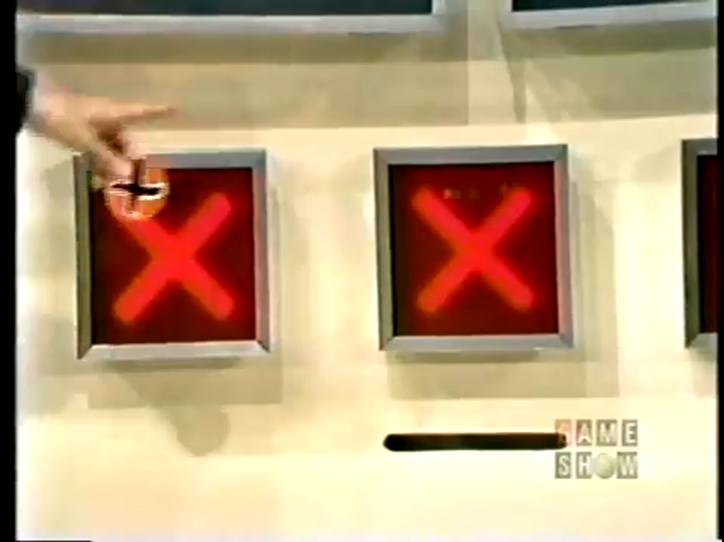 A hand is pointing at a game board with two red 'X' marks, indicating incorrect guesses in the game Three Strikes.