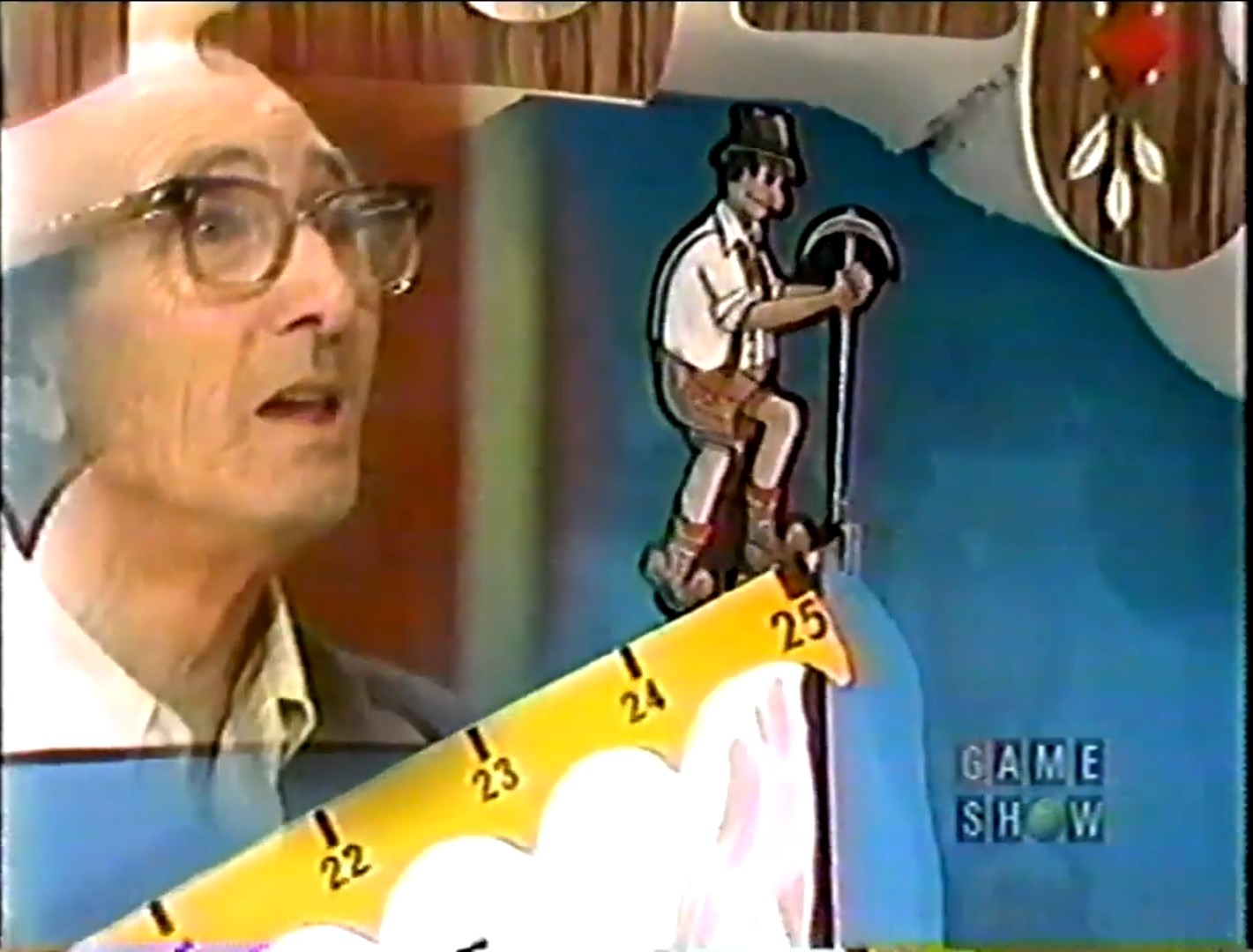 A contestant watches as the mountain climber figurine ascends a game board marked with steps numbered 1 to 25, displaying an intense expression.