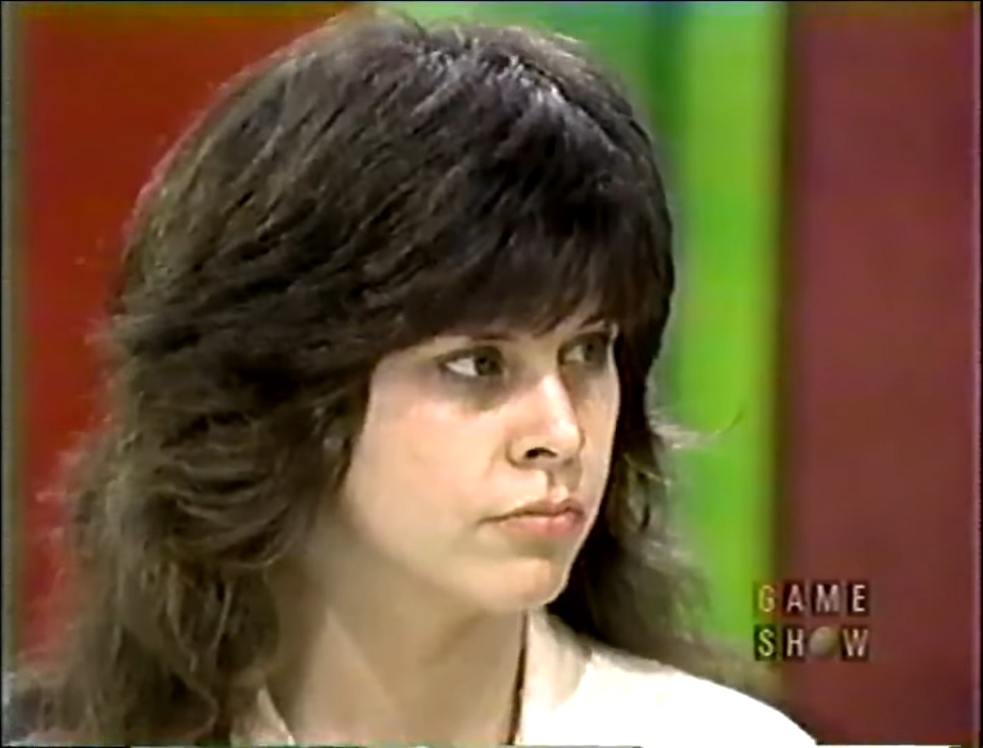 A contestant focused on the game during a tense moment on The Price is Right, with a colorful background.