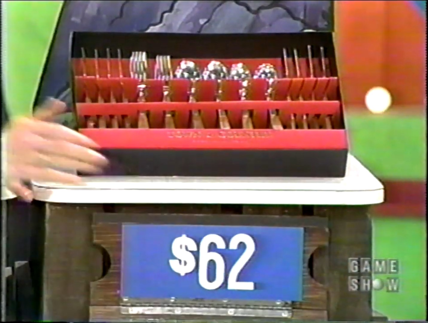 A boxed set of cutlery displayed on a stand, with a price tag of  visible beneath it.