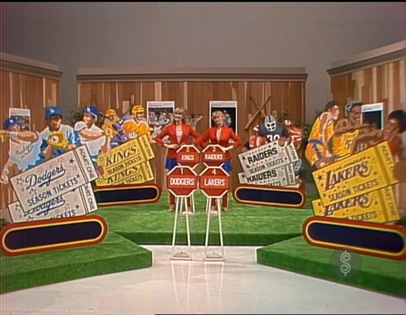 Contestants and audience members holding sports teams' season tickets, including Dodgers, Raiders, Kings, and Lakers, on a colorful Price is Right set.