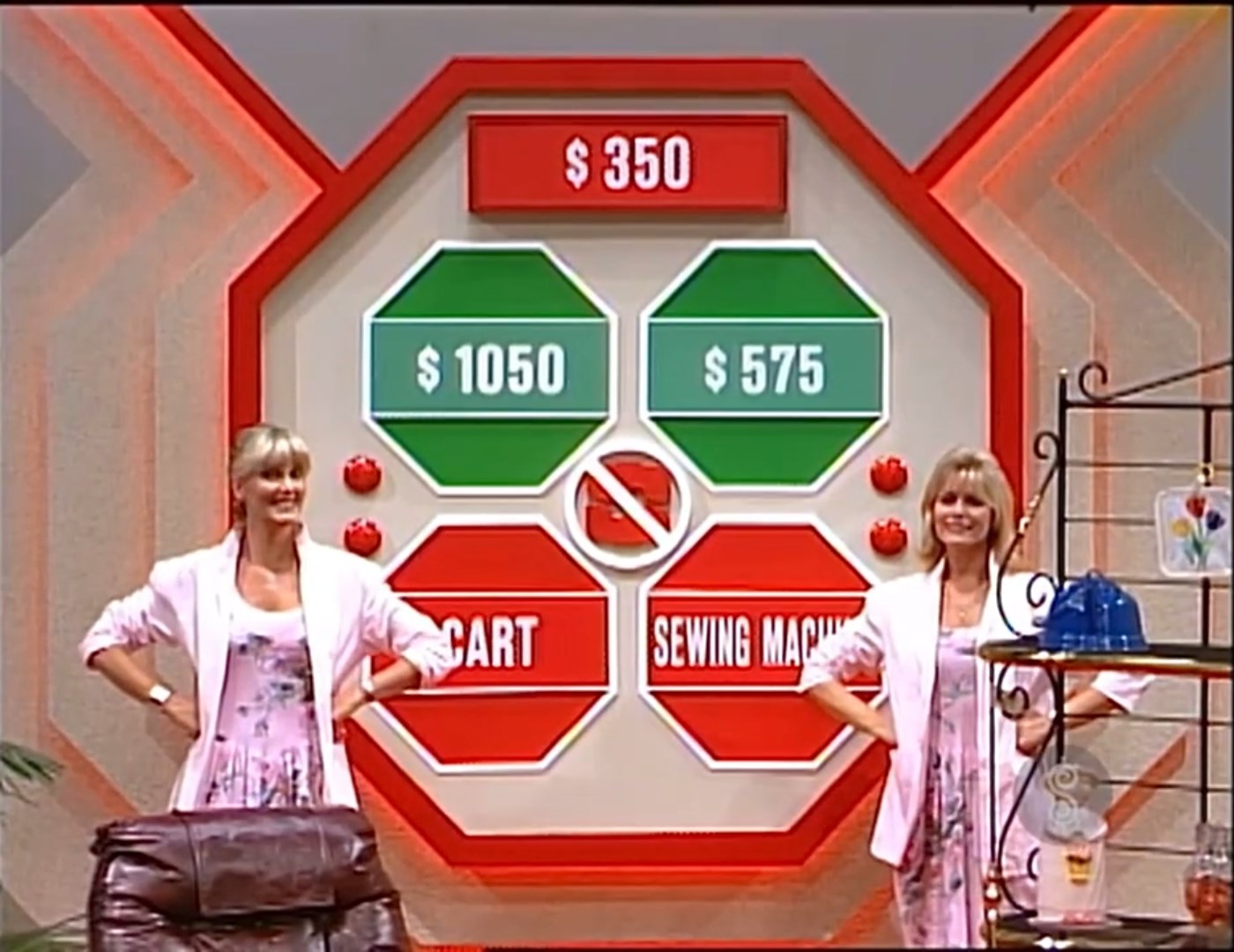A game board for 'Danger Price' featuring four prizes with different dollar amounts: 0, 50, 5, and a sewing machine. Two women stand on either side of the board, smiling.