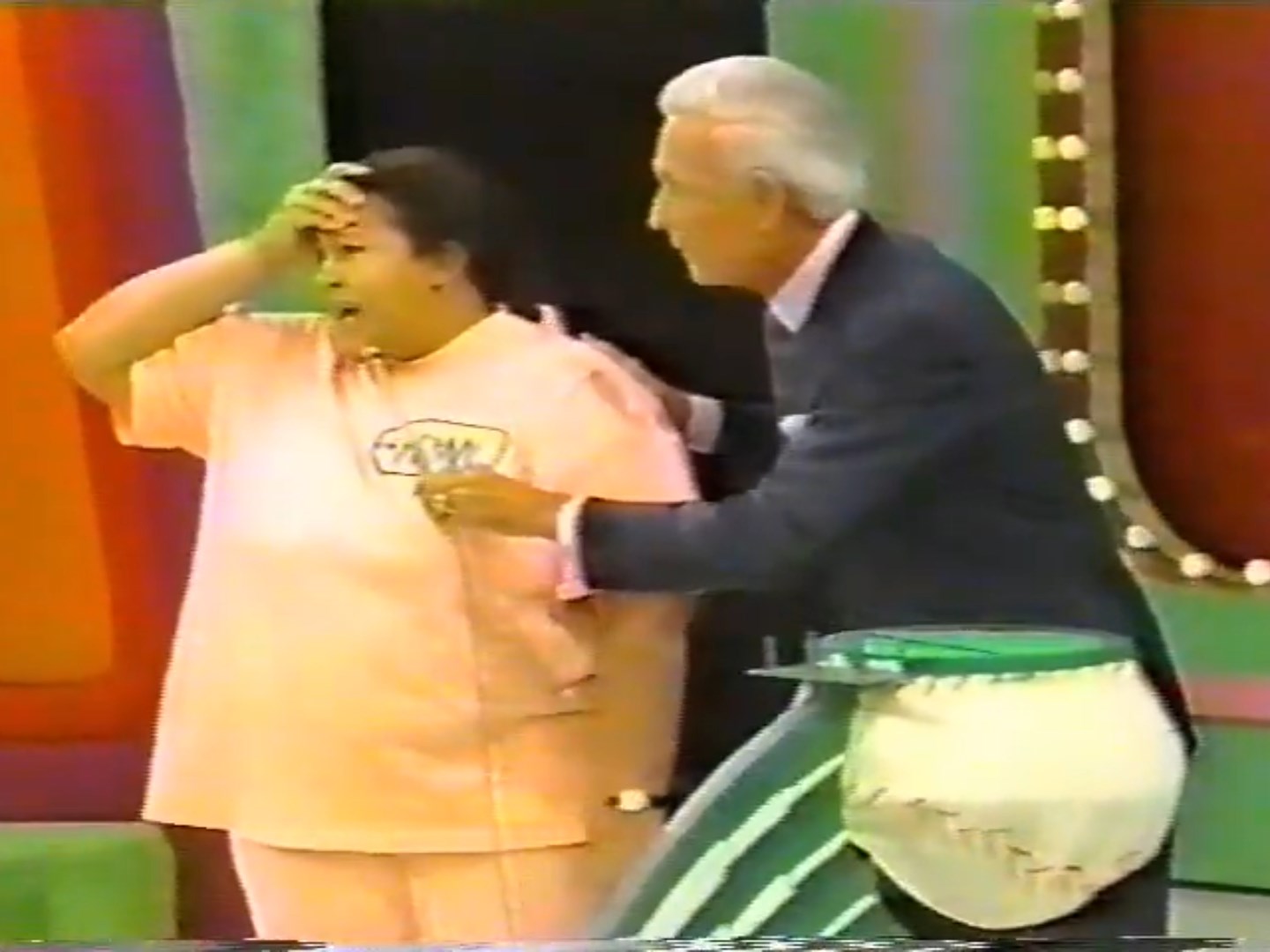 A contestant appears anxious while interacting with the host, who has a baseball-themed prop at his waist, during a game on The Price is Right.