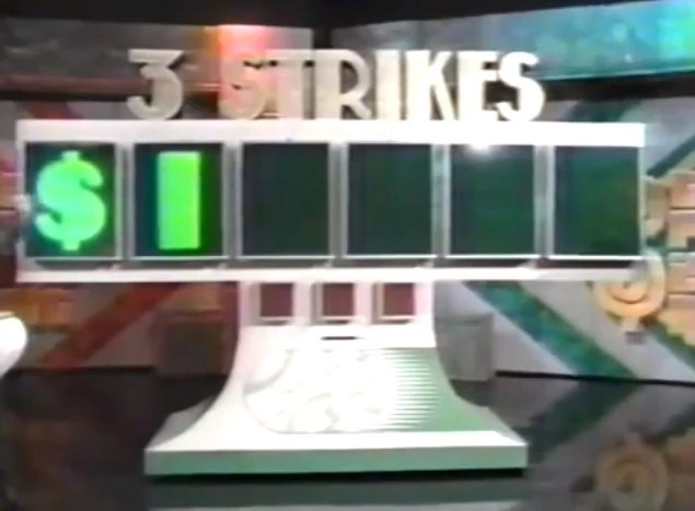 Three Strikes game display featuring four concealed windows, with the dollar sign and one revealed digit.