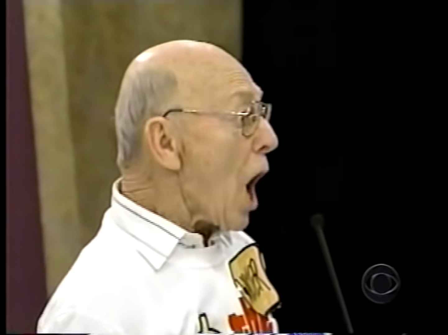 A contestant enthusiastically participates in The Price is Right, wearing a name tag and expressing excitement.