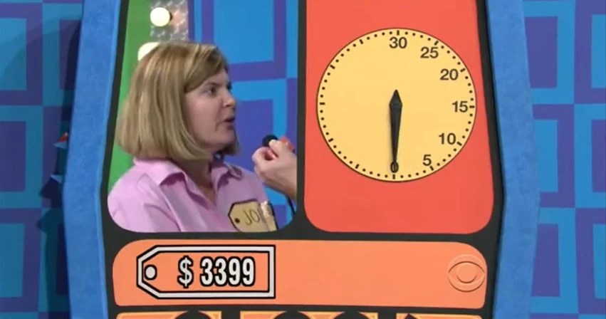 A contestant on The Price is Right playing the Clock Game, with a visible price tag of 99 and a countdown clock showing no time remaining.