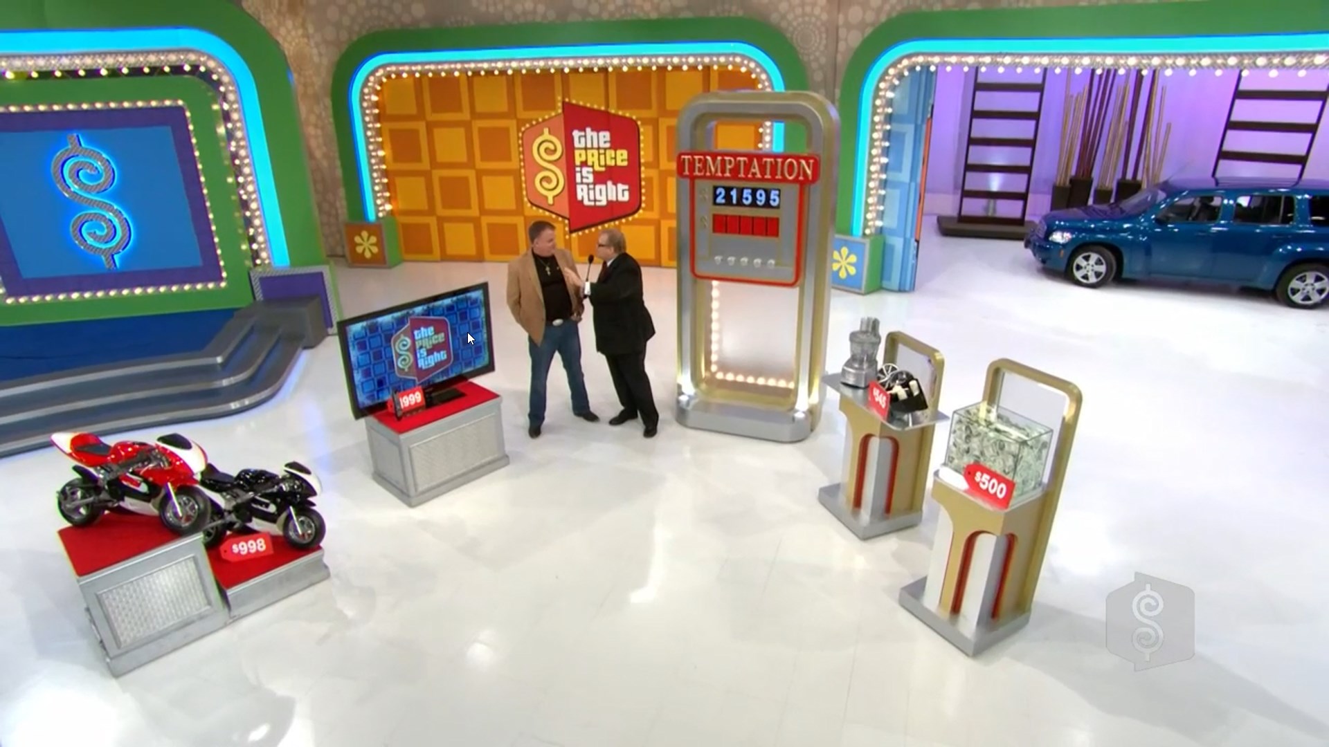 A game show set featuring the game "Temptation" from The Price is Right, with a contestant and host discussing results, surrounded by prizes including a motorcycle and cash display.