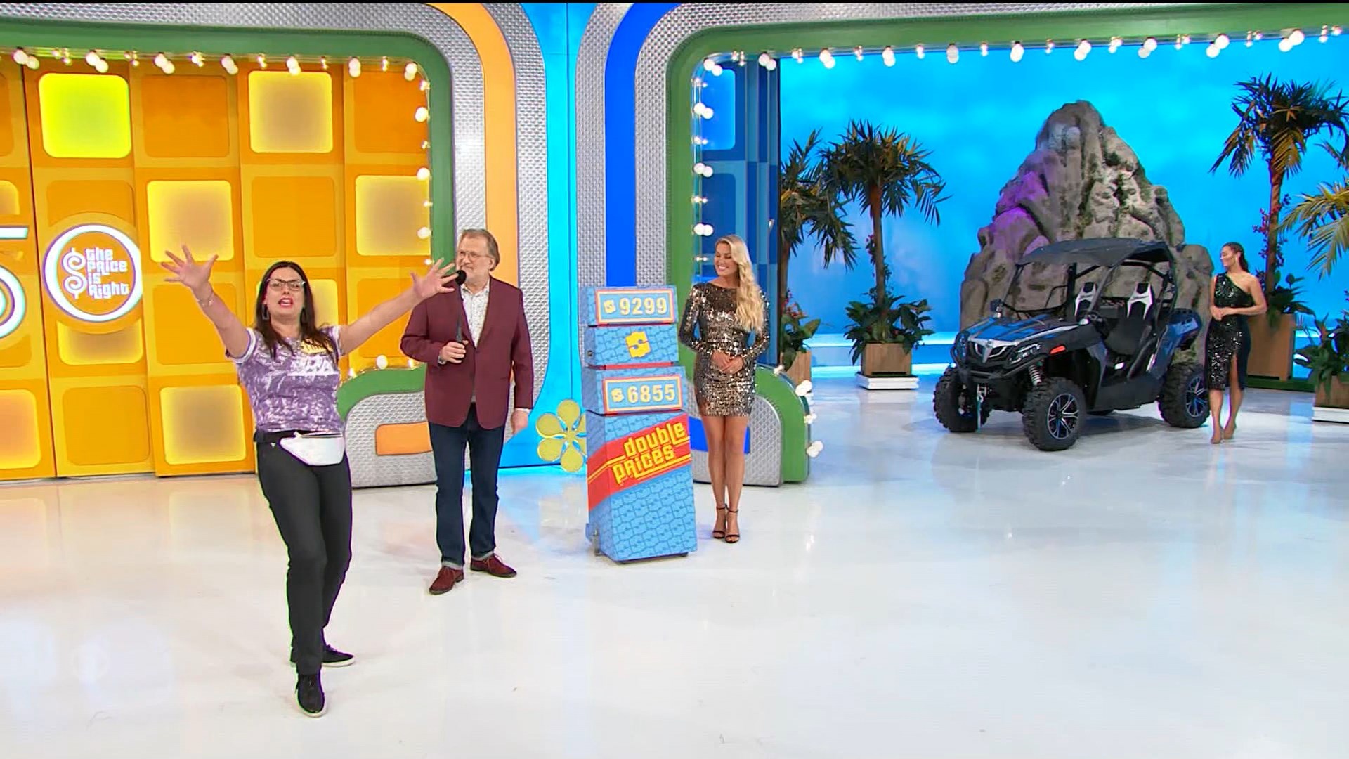 Contestant enthusiastically presents the Double Prices game with a colorful backdrop, featuring two price tags and a vehicle on display.