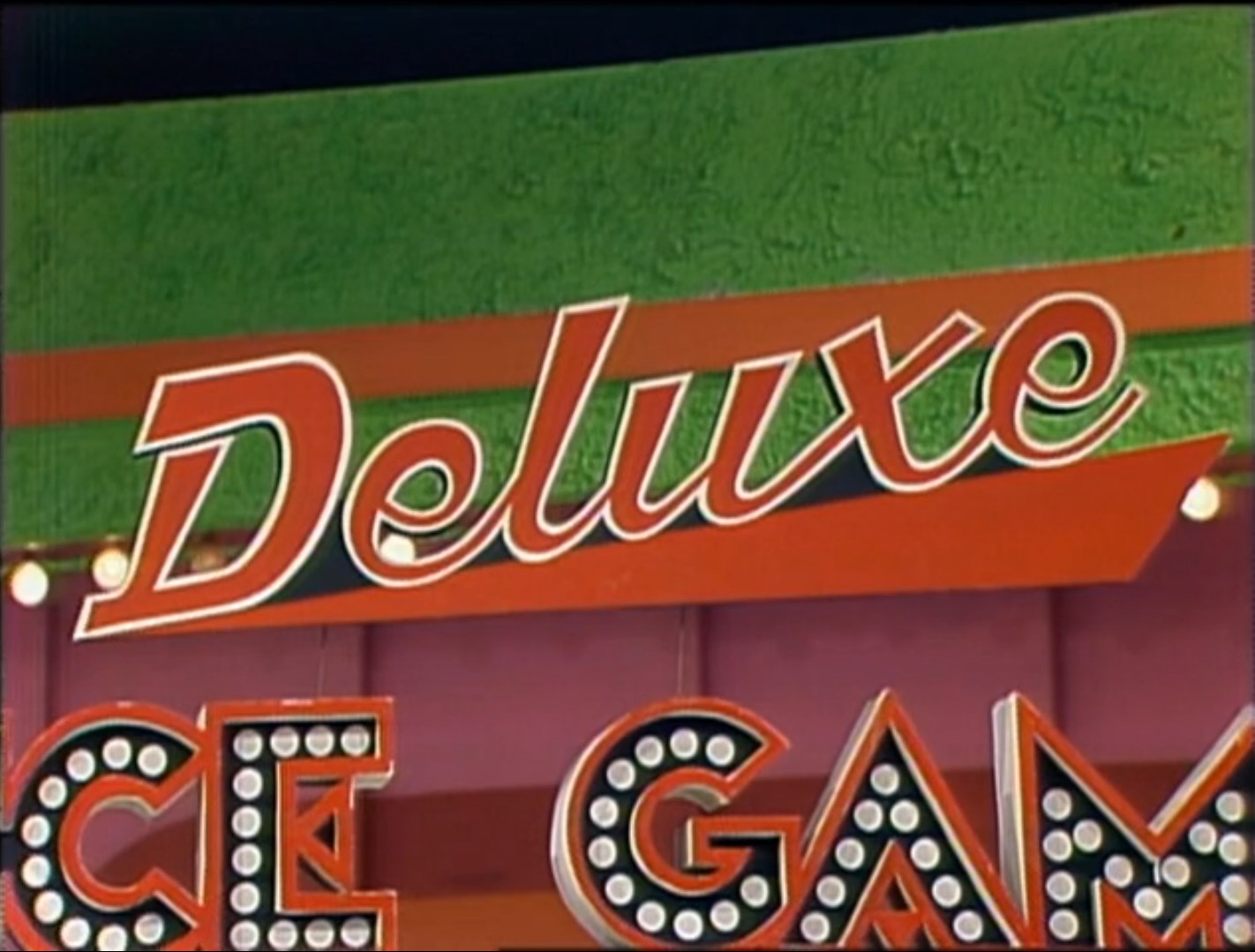 The sign for 'Deluxe Dice Game' featuring bold letters and colorful background.