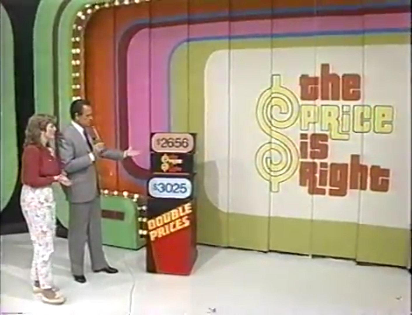 A game show scene from 'The Price is Right' featuring a host and a contestant beside a display showing two prices: 56 and 25 for a prize, with the show's logo in the background.