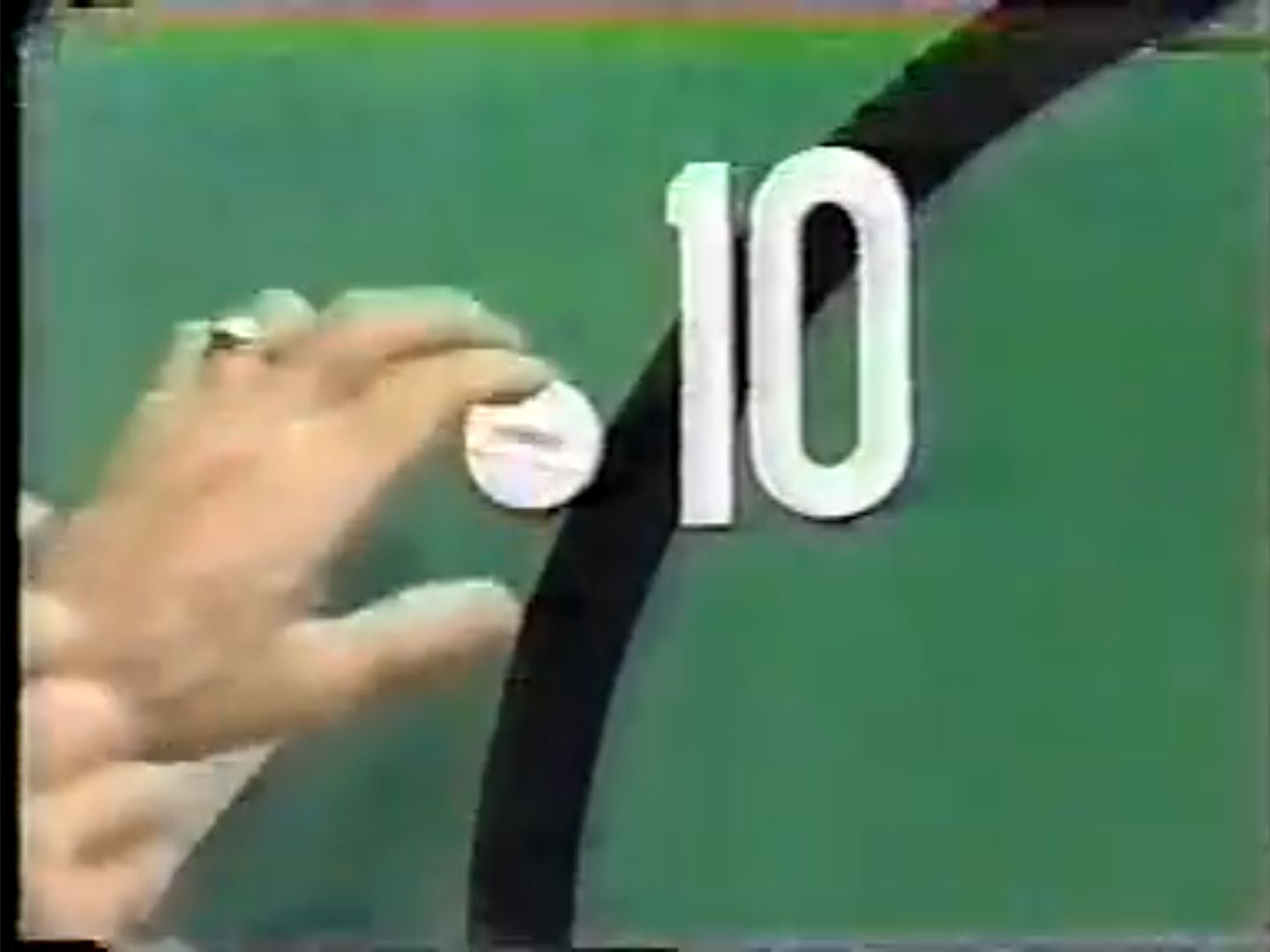 A close-up of a hand placing a marker on a target with a bullseye, indicating the number 10.
