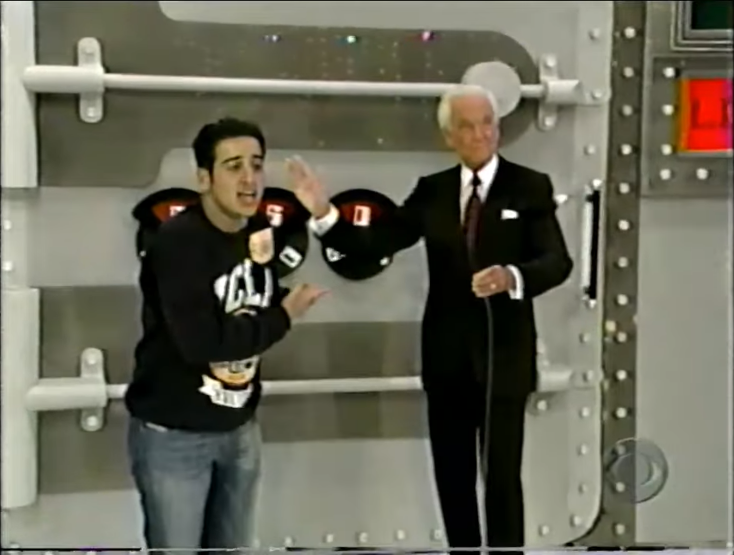 Contestant excitedly gestures while Bob Barker demonstrates the Safe Crackers game setup.