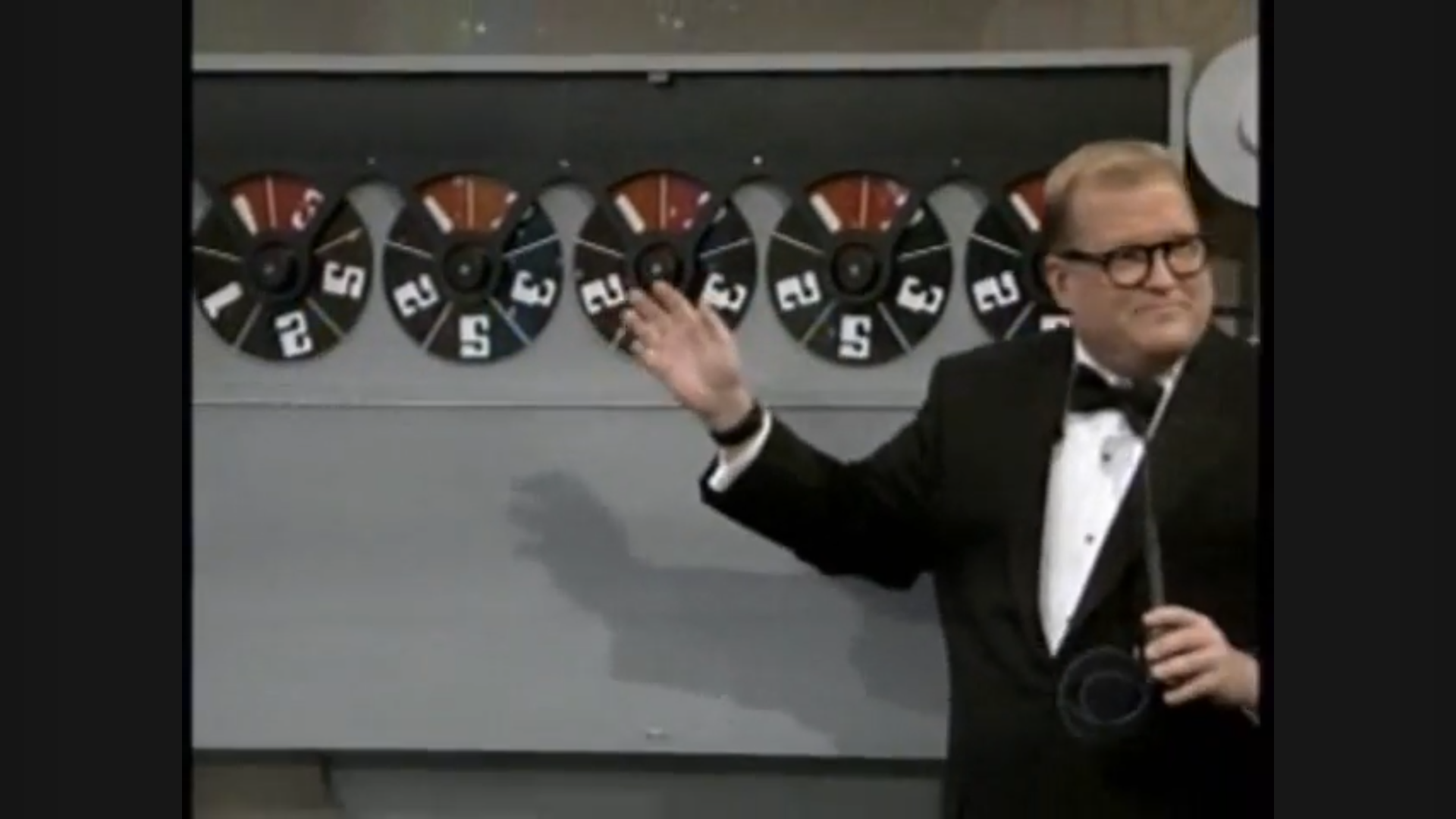 Drew Carey presenting the Safe Crackers game board with spinning dials showing various numbers.