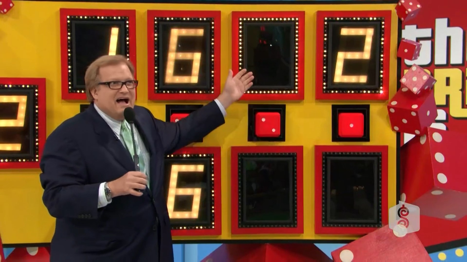 Drew Carey enthusiastically presenting the Dice Game setup with numbers and oversized dice in the background.