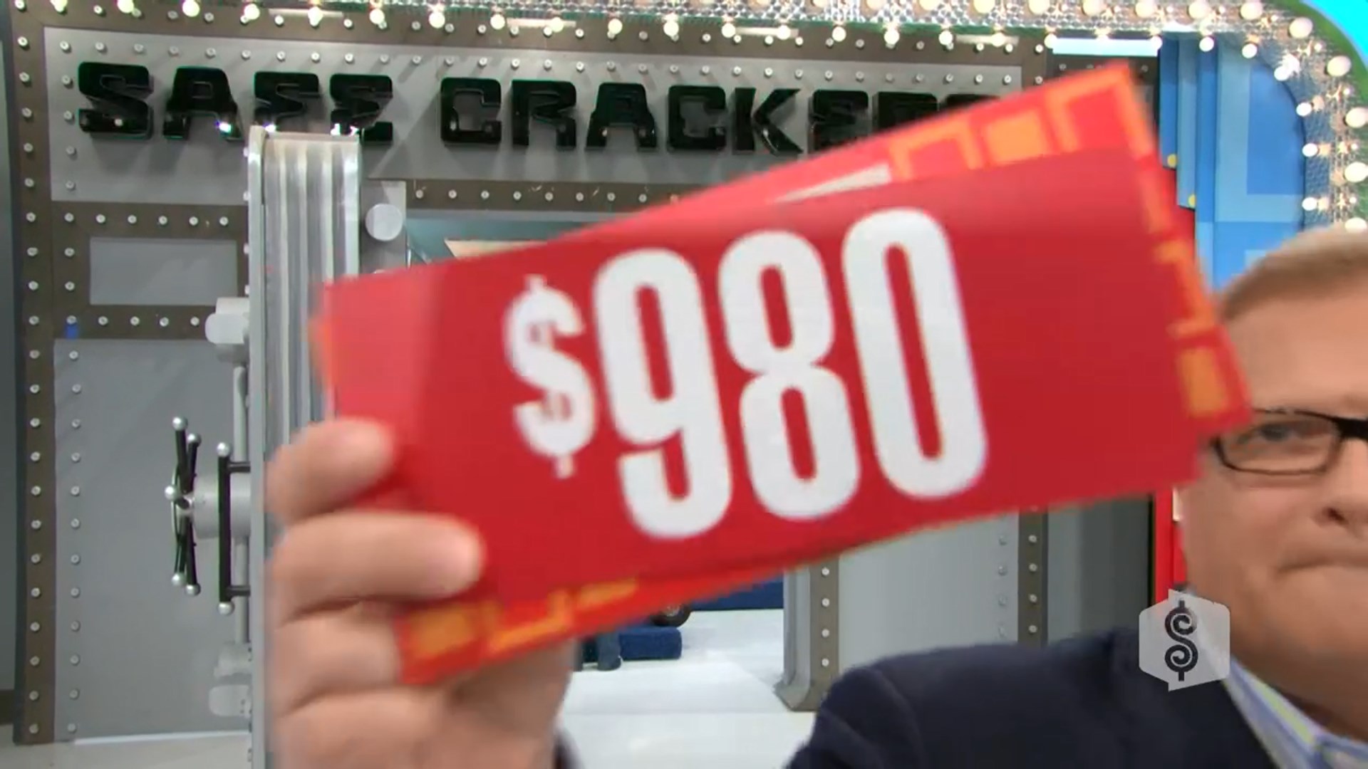 Drew Carey holds up a red card displaying the price 0 in front of a safe during the game 'Safe Crackers' on The Price is Right.