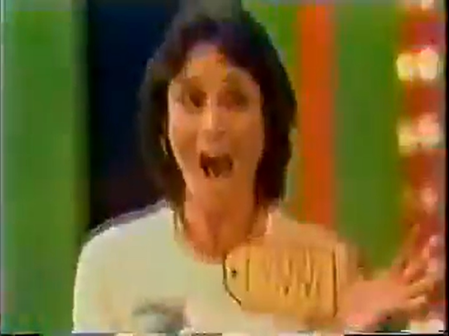 Excited contestant on The Price is Right holding a game showcase price tag and smiling.