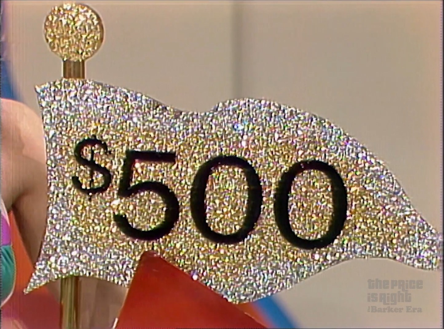 A light gold $500 flag in Hole in One from 1983 with silver trim on the borders.