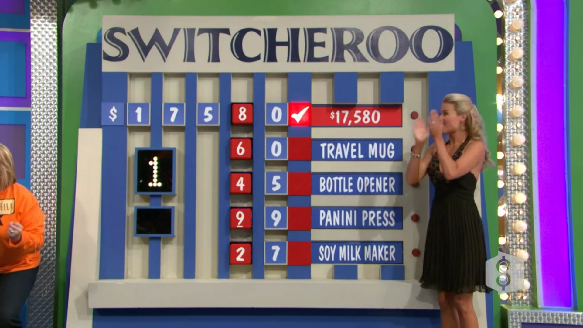 A contestant celebrates after revealing the price of ,580 on the Switcheroo game board, which features five prizes with corresponding numbers below each.