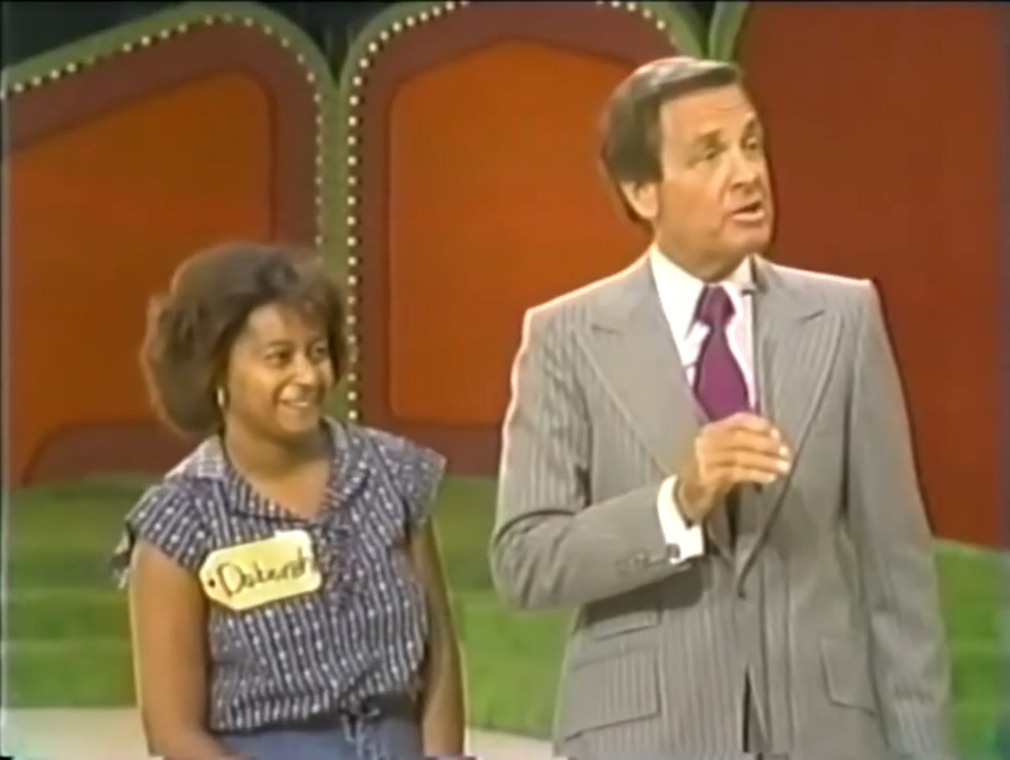 A woman named Deborah smiles alongside host Bob Barker on stage during a game segment of The Price is Right.