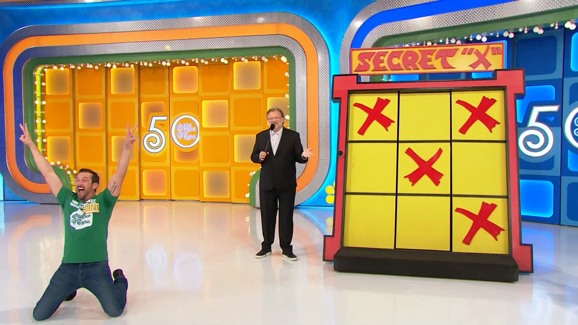 A contestant celebrates on the set of The Price is Right, kneeling with raised arms in excitement, next to the Secret 'X' game board displaying three red X's on a yellow background.