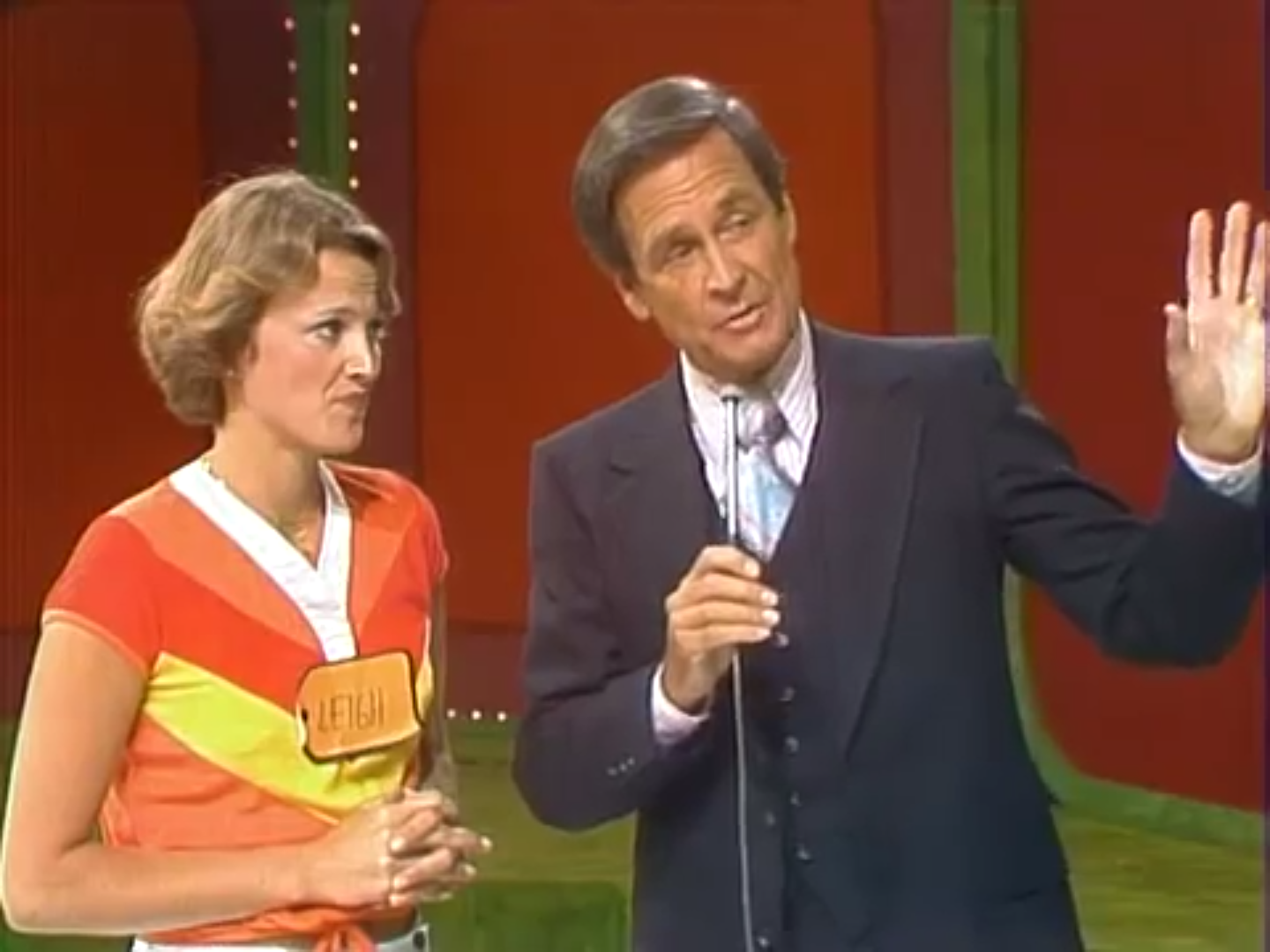 A contestant named Leigh stands beside the host, both looking serious, as they discuss the game on 'The Price is Right'.