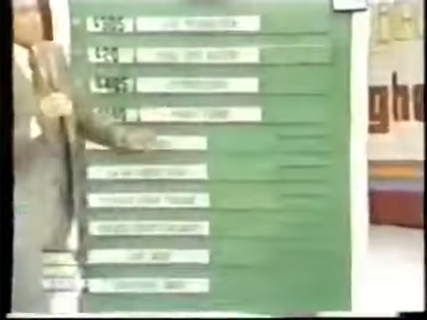 A host stands beside a green board displaying various options related to the game 'It's Optional' on The Price is Right.