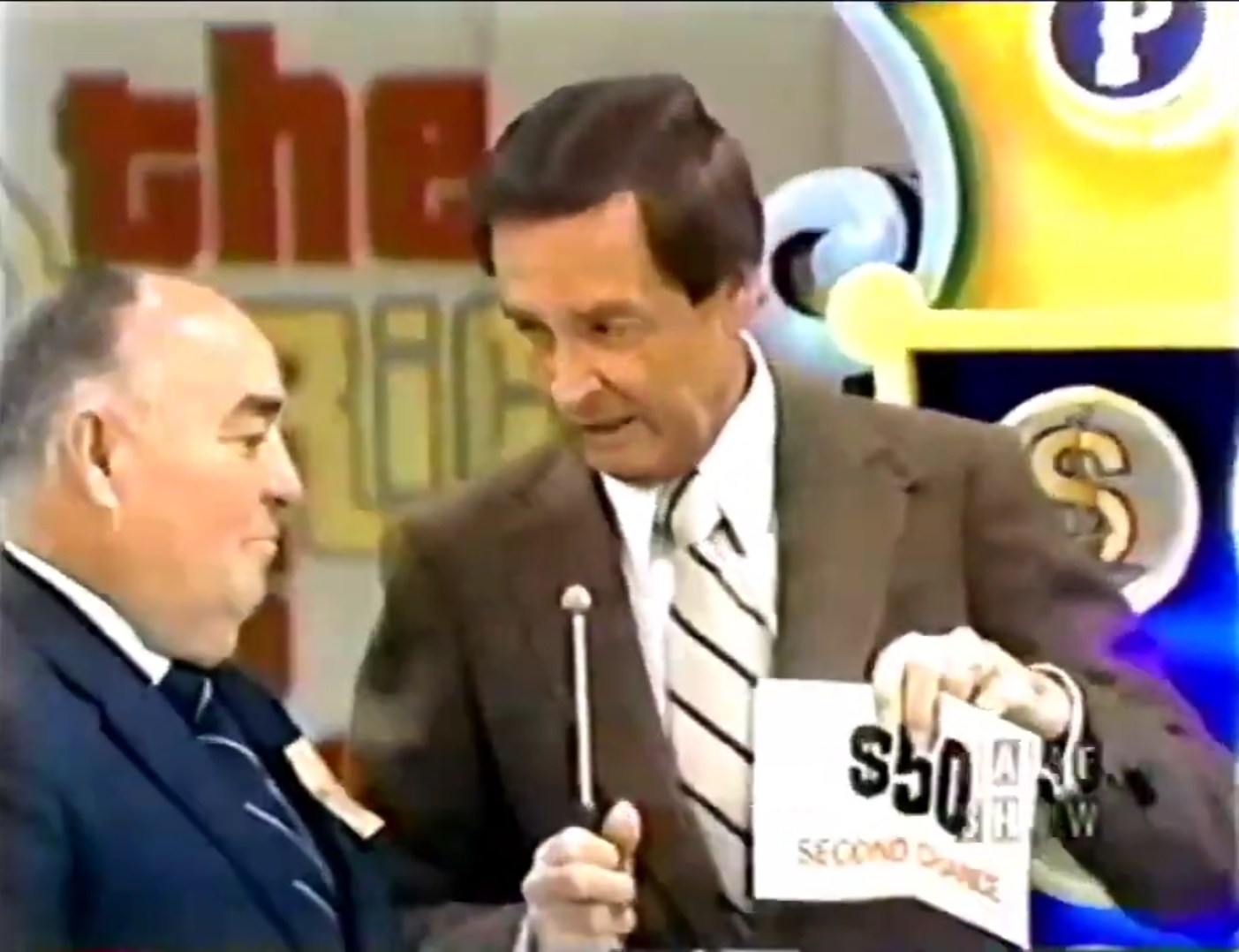 A game show host presents a contestant with a card that reads 'SECOND CHANCE' and a cash amount, on the set of The Price is Right.