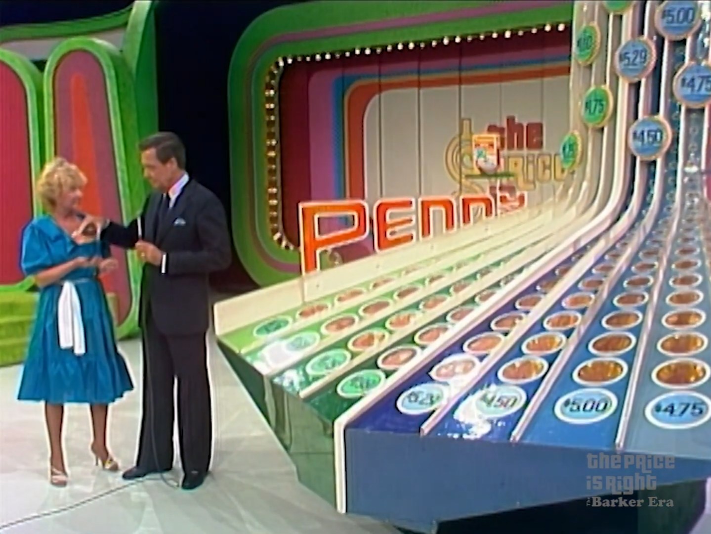 Contestants engaging in the Penny Ante game show with a colorful set featuring price labels and a gameboard.