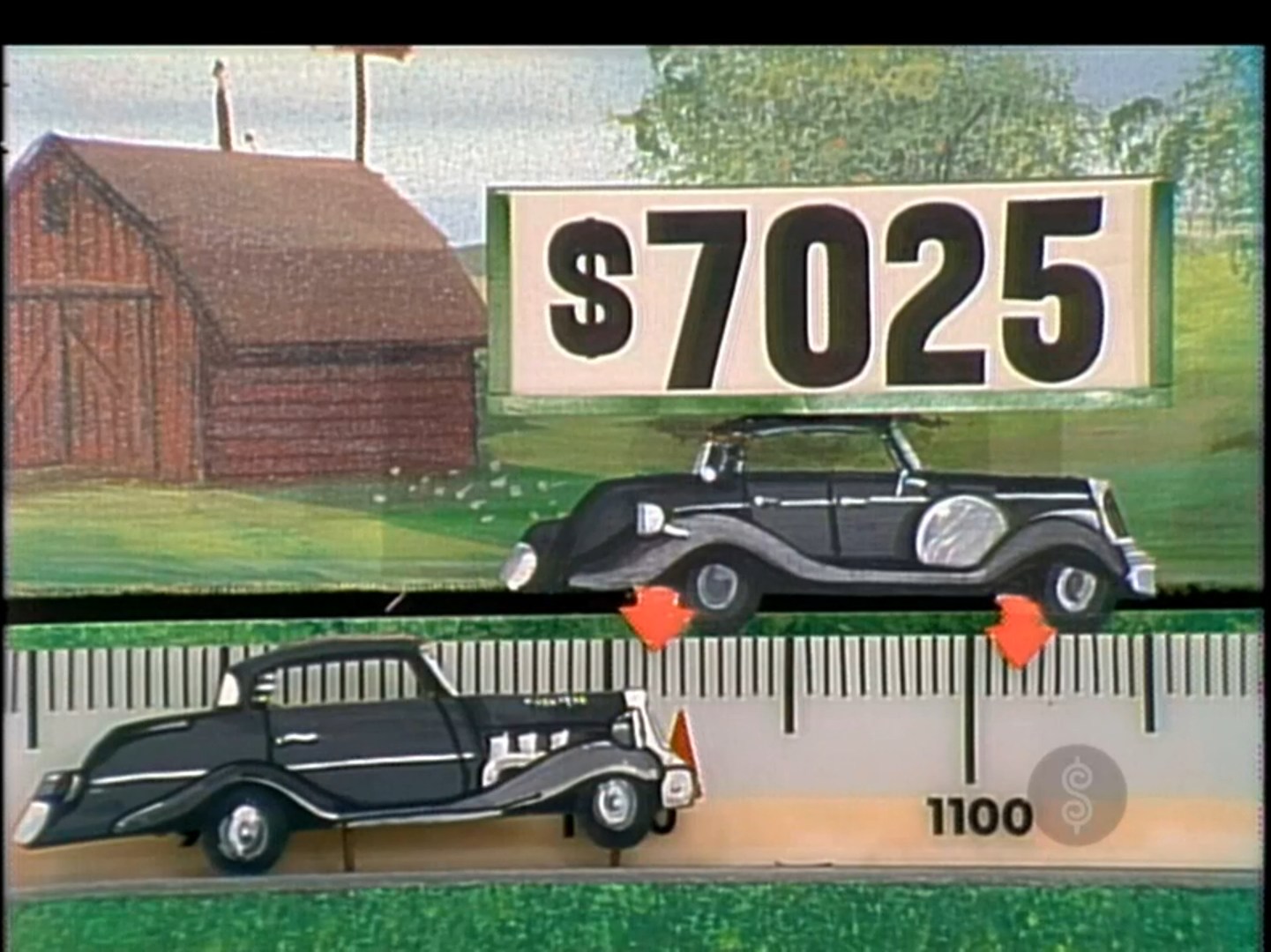 A game display from The Price is Right featuring two toy cars, one above the price 25 and another on a ruler marked up to 1100.