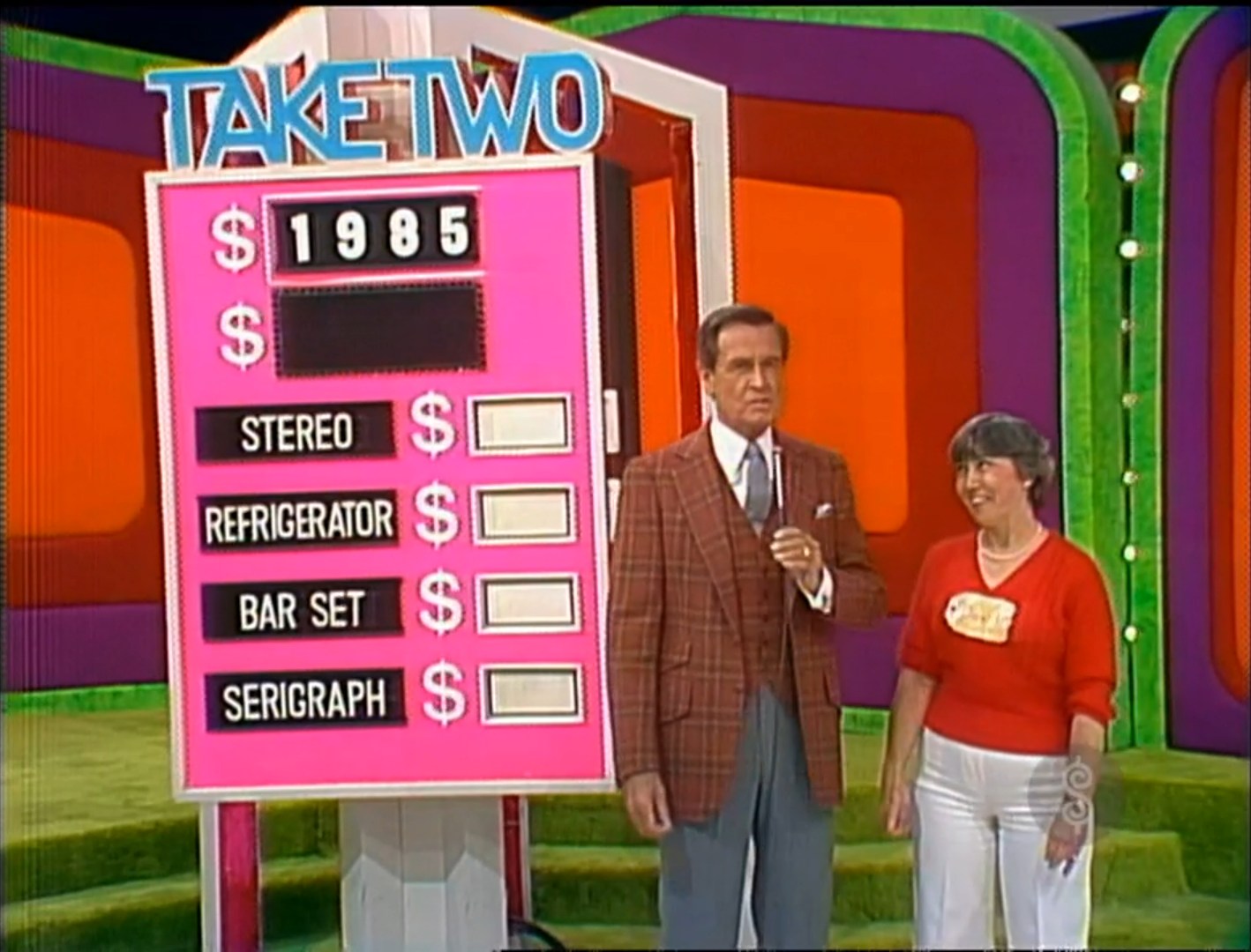 A game show scene depicting a host and a contestant standing beside a large game board labeled 'TAKE TWO' with a target price of 85 and four prizes listed: Stereo, Refrigerator, Bar Set, and Serigraph.