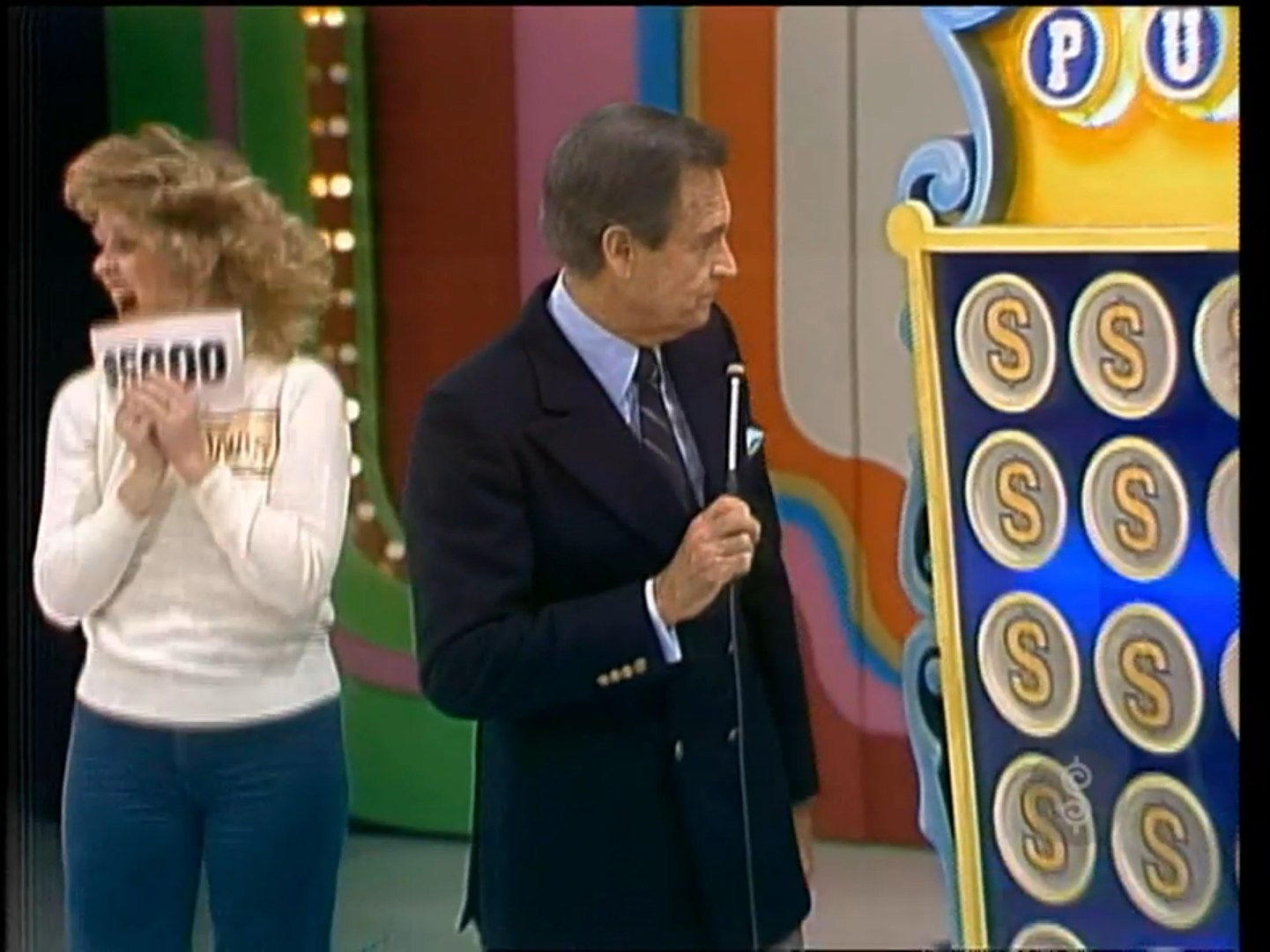 A contestant excitedly holds up a sign with the amount ,000 while standing next to the host at the Punch a Bunch game on 'The Price is Right'.