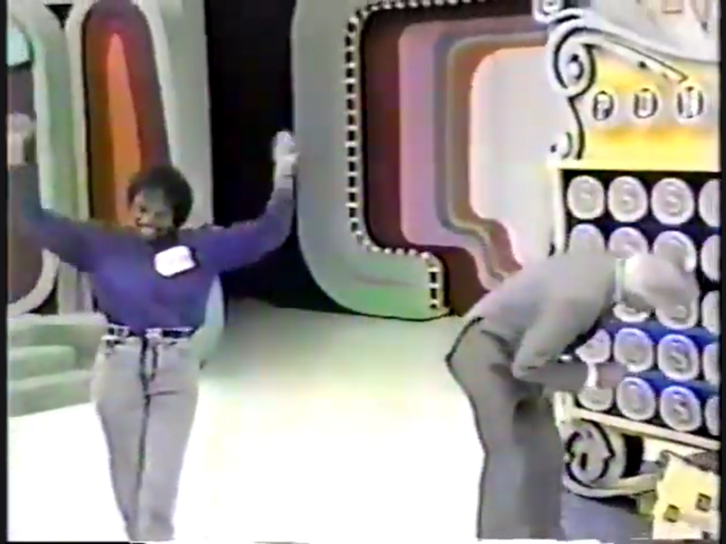 Contestant celebrates with arms raised while host interacts with the Punch a Bunch game board in a colorful studio setting.