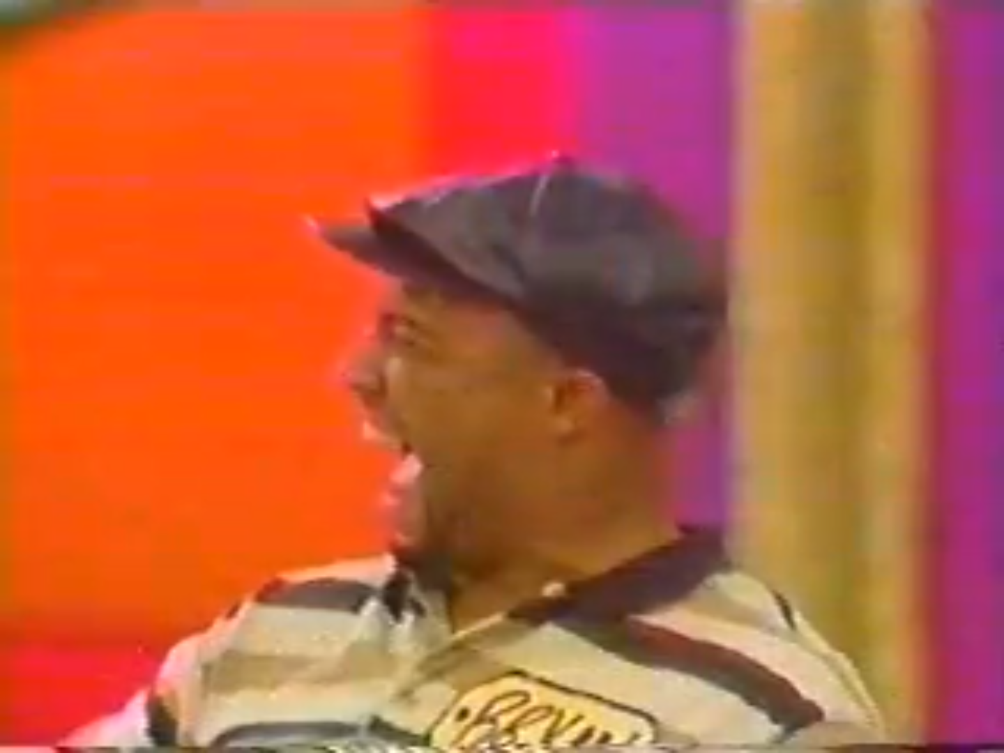 A contestant celebrating excitedly on stage during a game show, with colorful background lights.