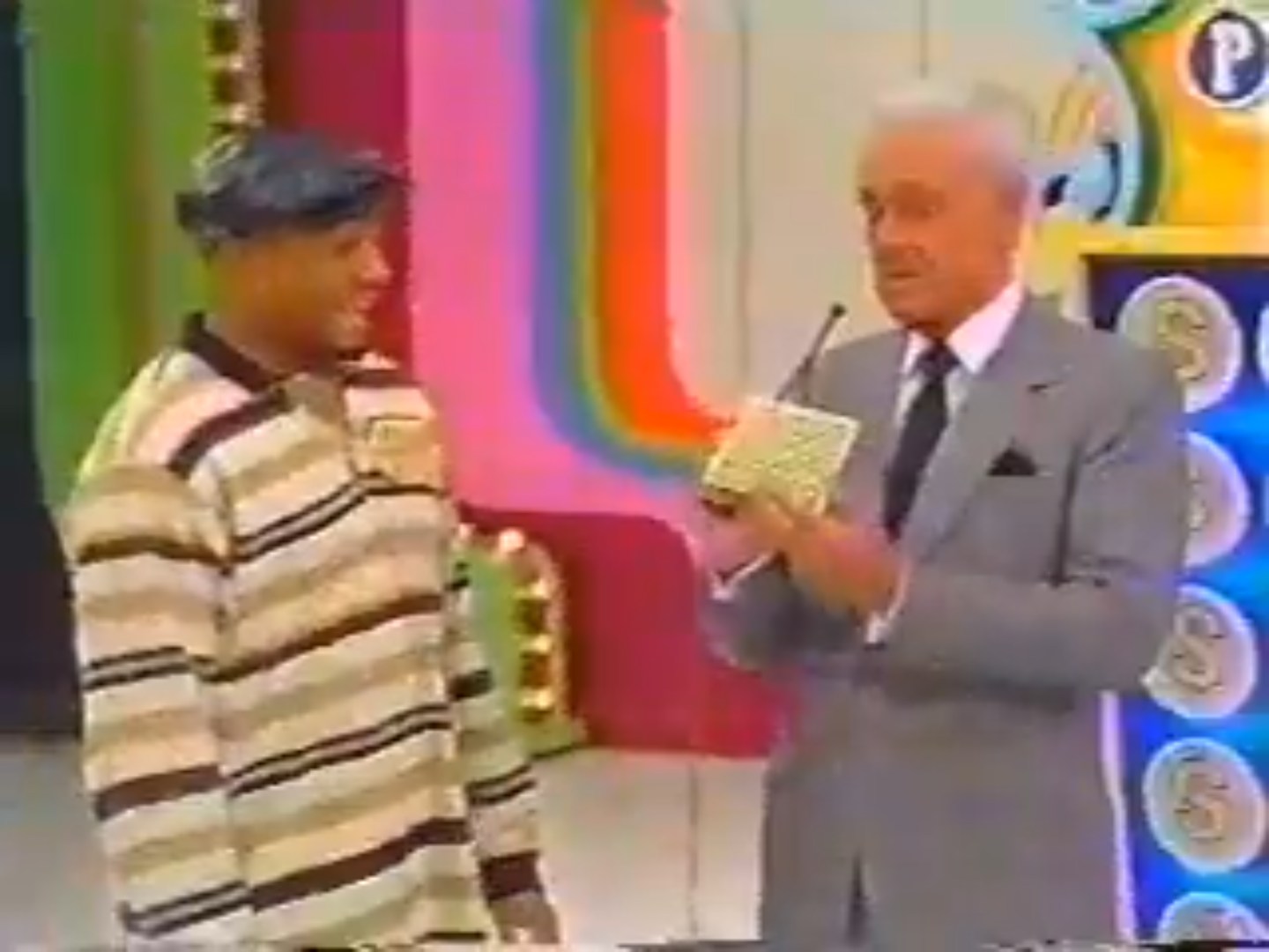 A contestant smiles as they prepare to play Punch a Bunch with the host, who holds the game's punchboard.