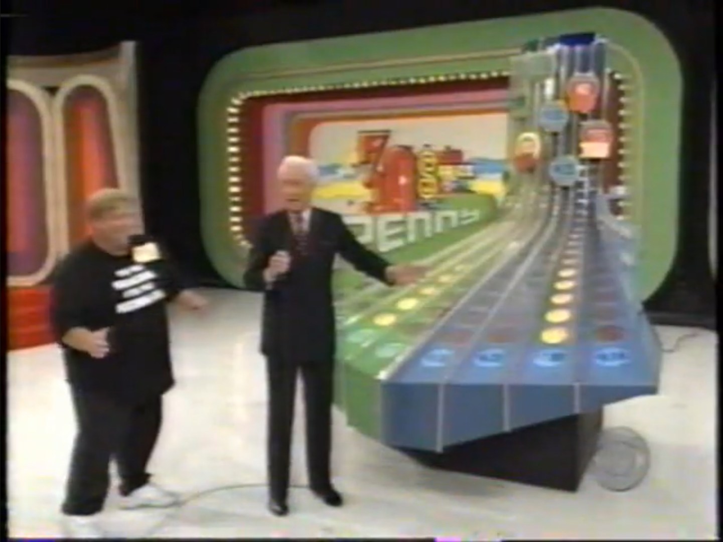 A contestant interacts with Bob Barker on the set of Penny Ante, showcasing the game's unique price reveal board.