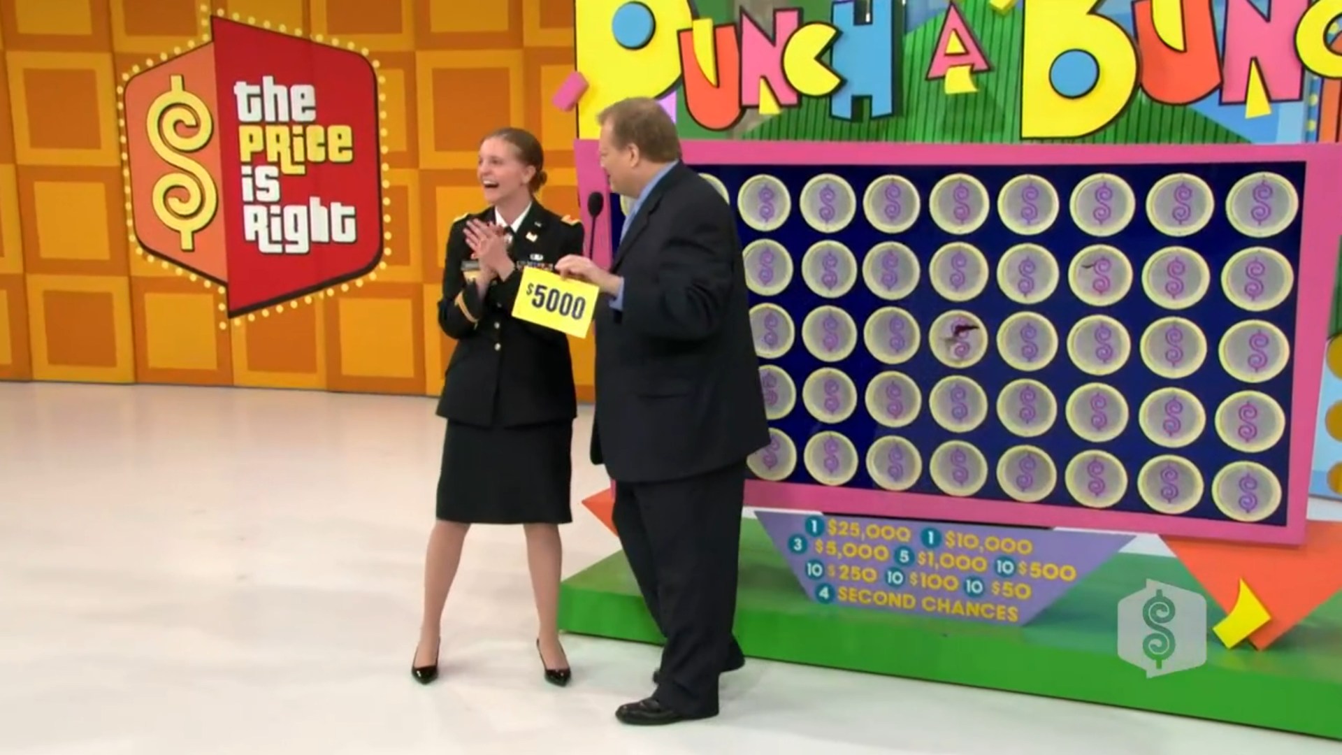 A contestant celebrating on the set of The Price is Right with a sign showing ,000 next to the Punch a Bunch game board.