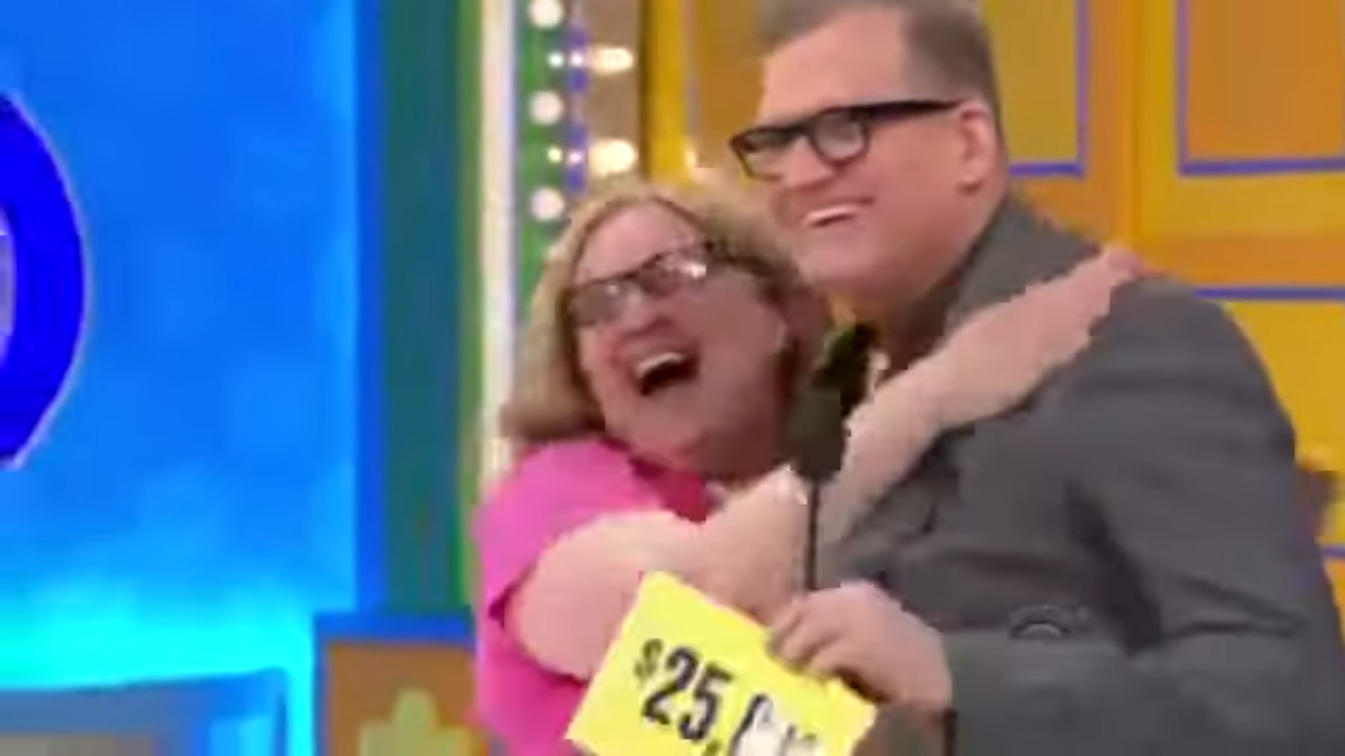 Contestant celebrating a win on The Price is Right, holding up a sign for ,000 with the host.