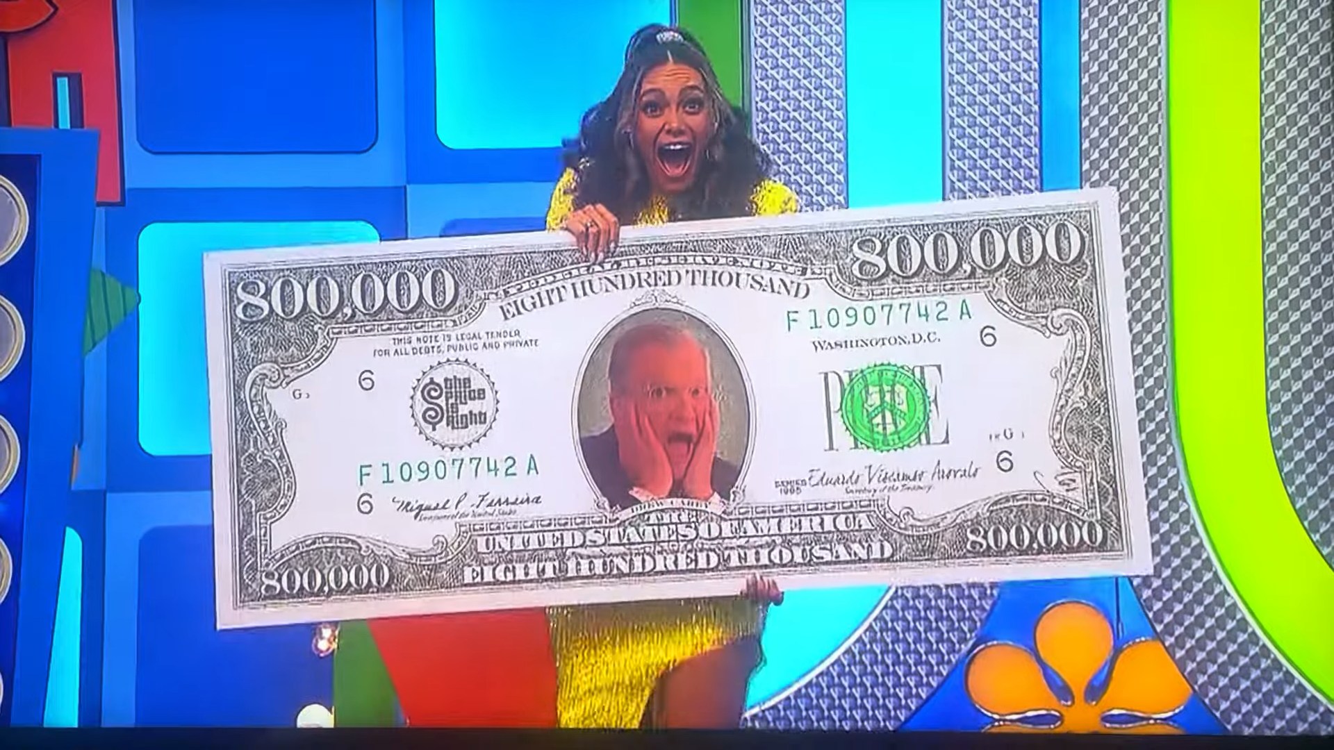 A contestant excitedly holds a large novelty check for 0,000 while smiling on the set of The Price is Right.