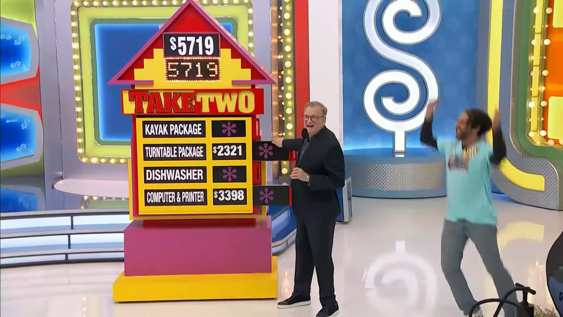 A game show host stands next to a colorful game board titled 'Take Two,' featuring four prize options with their respective prices listed, while an excited contestant celebrates in the background.