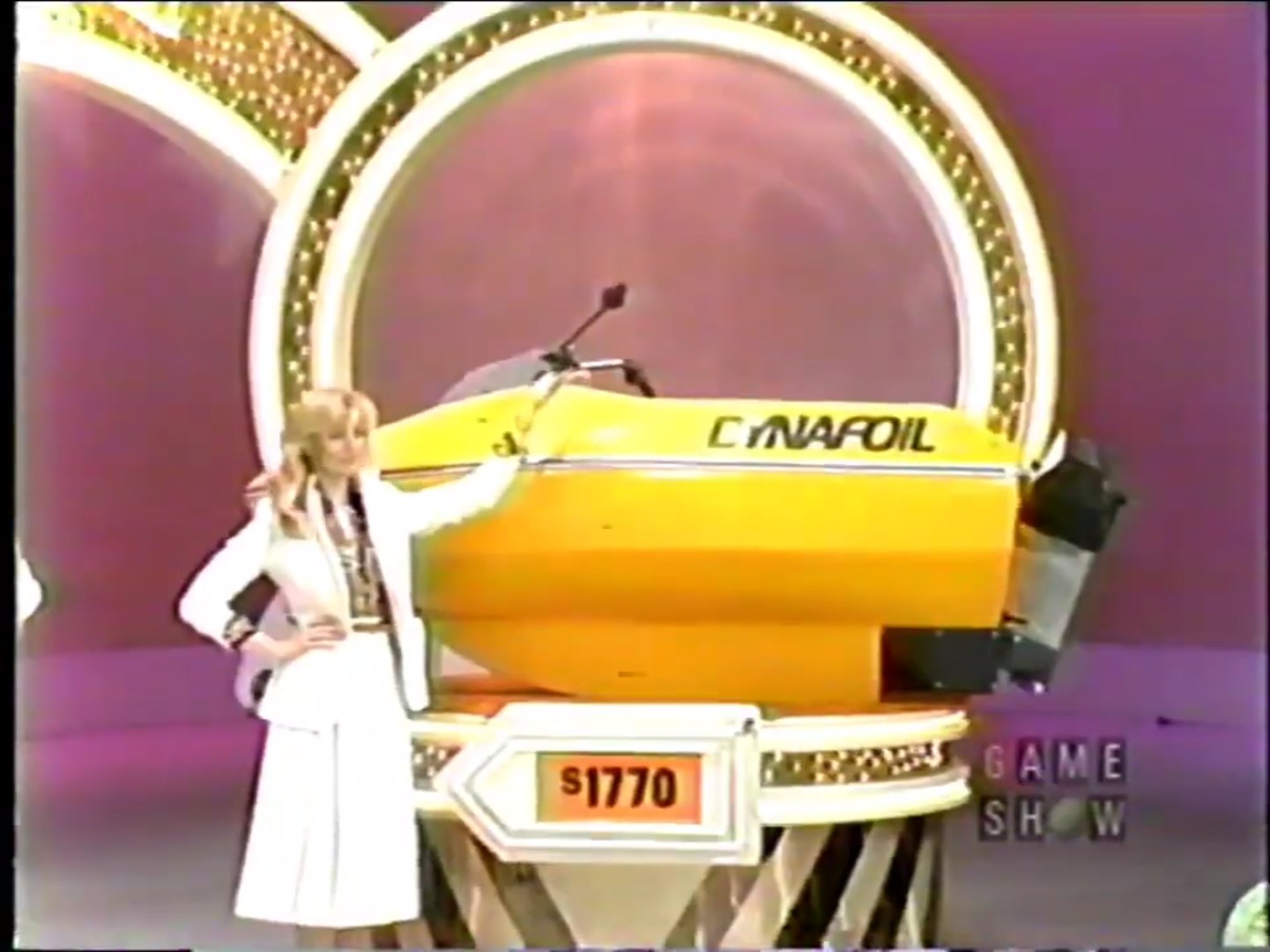 A contestant presents a bright yellow Dynafoil at the Bargain Game on stage, marked with a bargain price of 70.